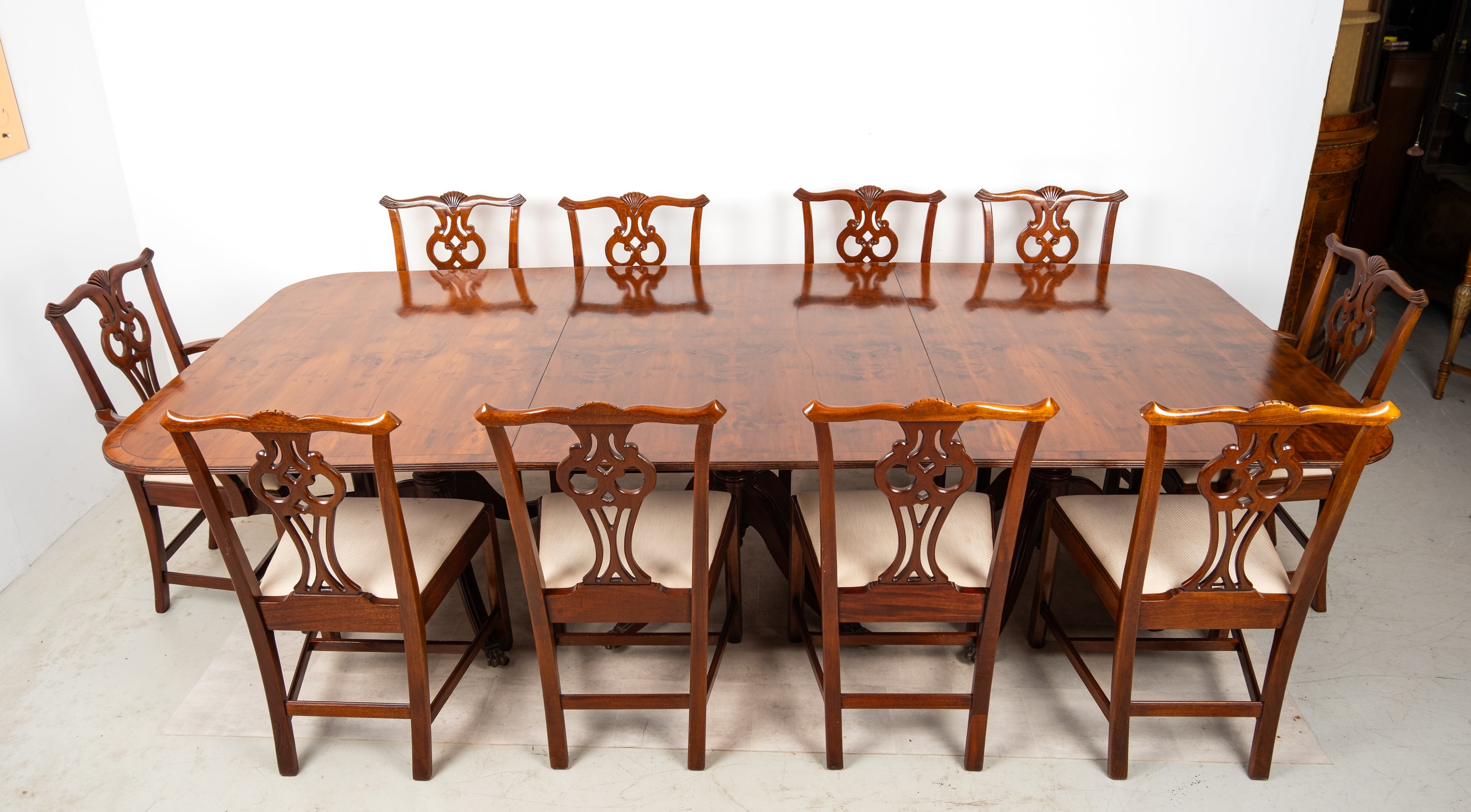 Vintage yew wood extending dining table with ten matching chairs including carver armchairs
