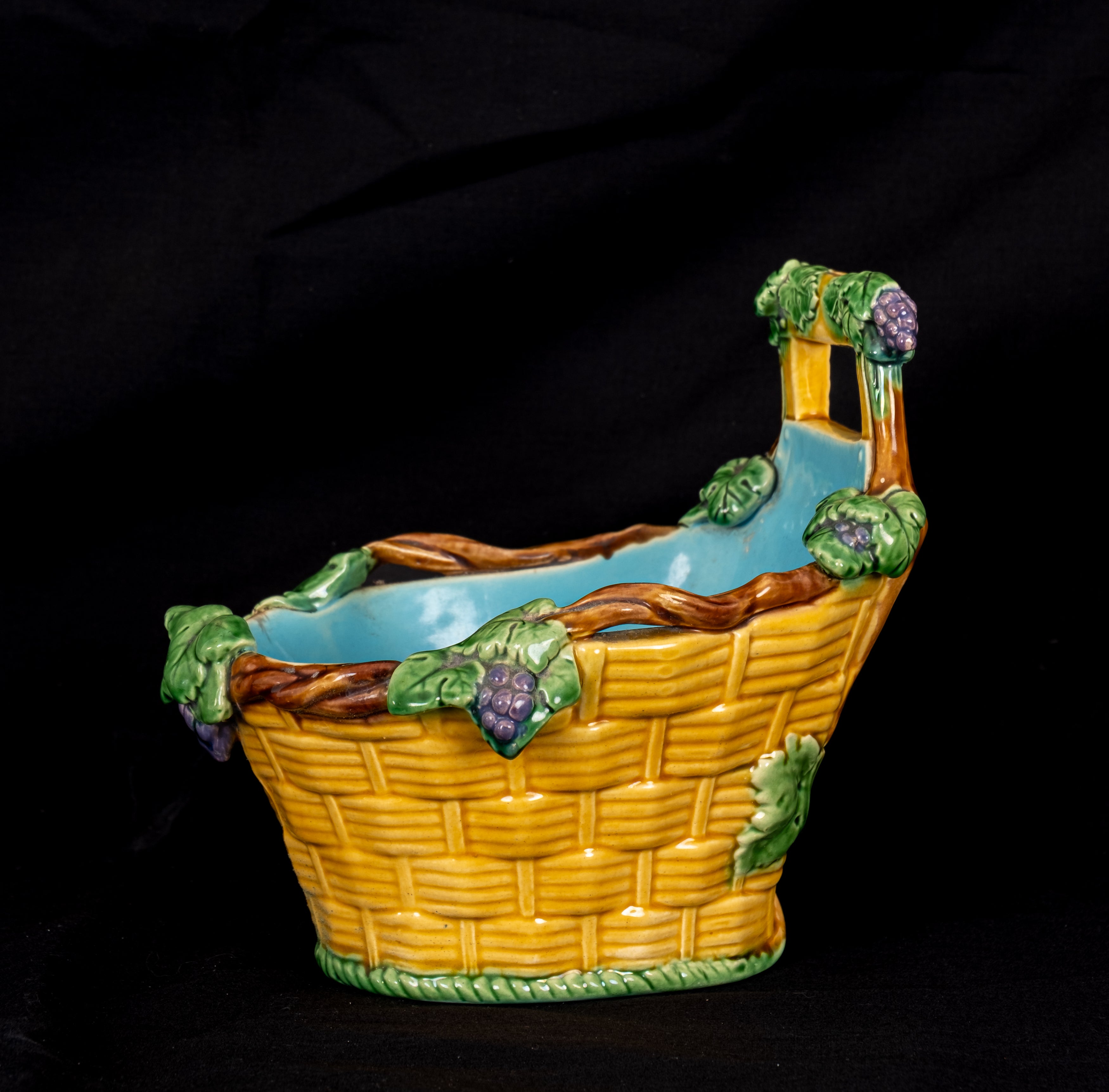 Antique Minton majolica basket jardinière circa 1860 with yellow wicker-effect body, turquoise interior, green vine leaves and purple grapes.