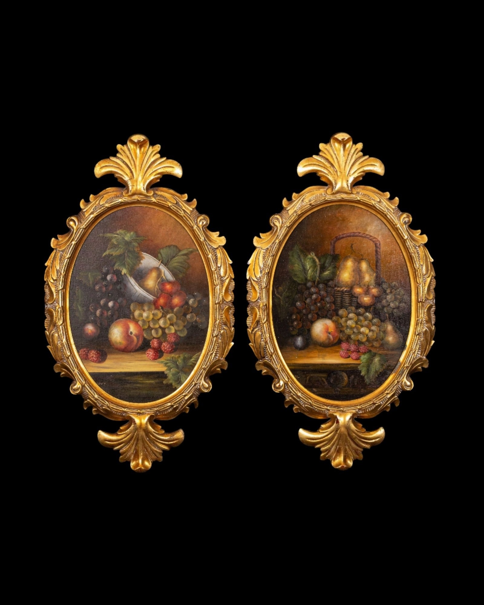 Pair of large oval fruit still life oil paintings in matching ornate gilt frames with foliate crests.