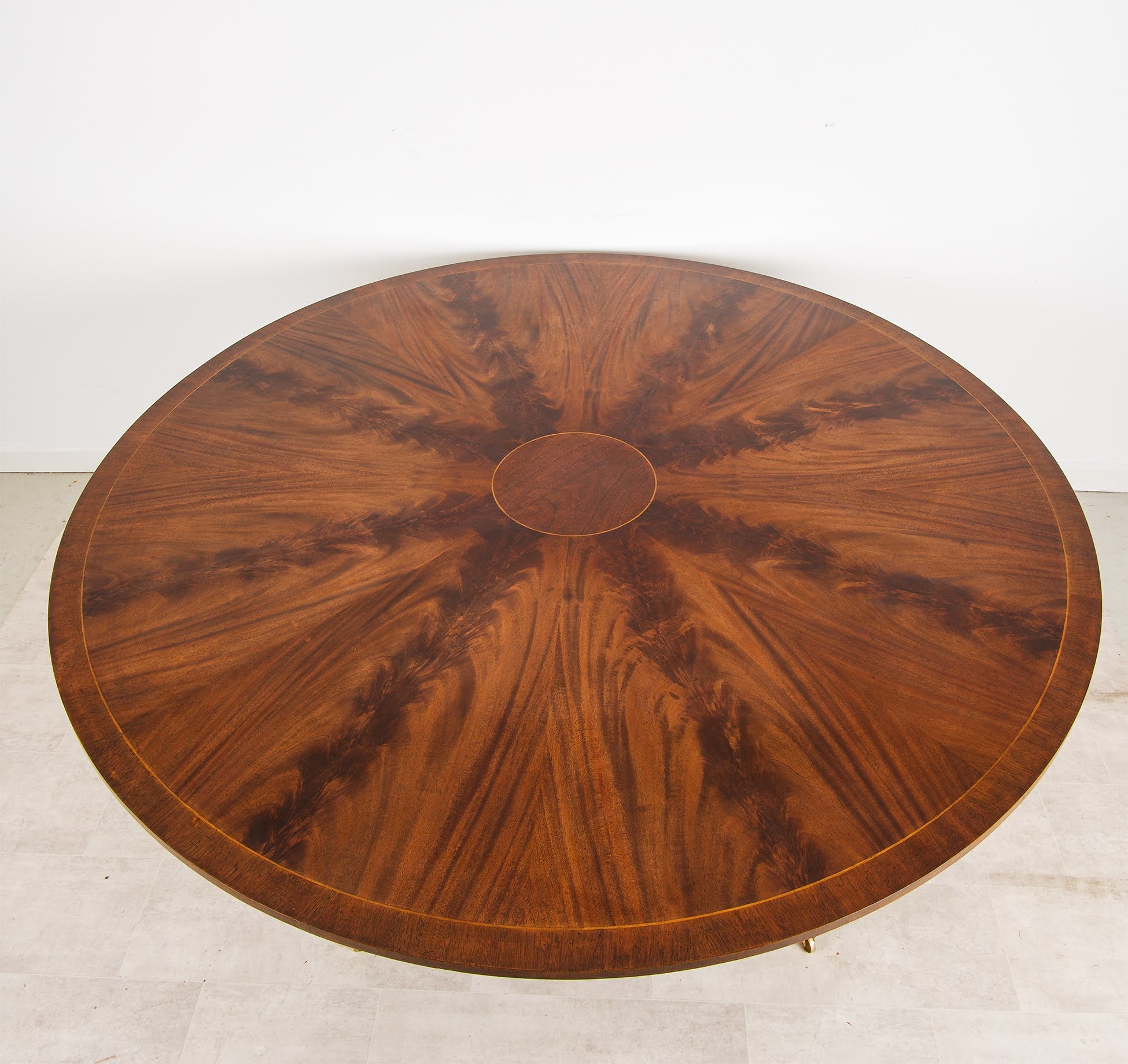 Figured flame mahogany circular dining table top with Regency styling
